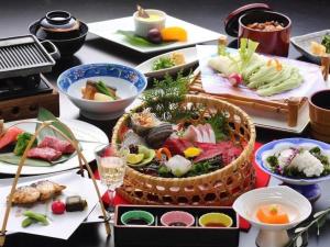 a table topped with plates of sushi and food at Shodoshima International Hotel in Tonosho