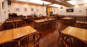 a restaurant with wooden tables and chairs in a room at Petit Hotel Key West Club in Naha