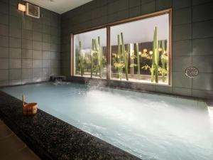 a large swimming pool with a window in a building at Super Hotel Arai-Niigata in Myoko