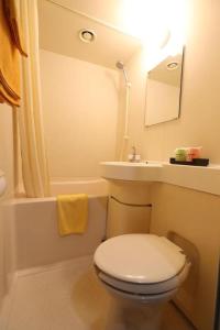 a white bathroom with a toilet and a sink at HotelNewYama in Yamanouchi