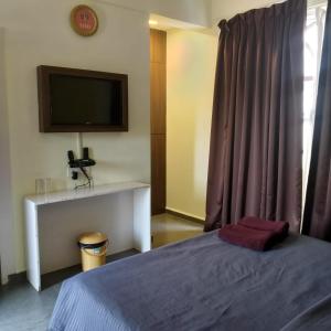 a bedroom with a bed and a tv on the wall at casa titos in Jāmb