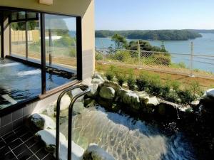 a bath tub with a view of the water at Ikadasou Sanjou in Shima