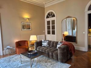 Una sala de estar con un sofá y un espejo. en The Grand 42 - stylish apartment, en Carcassonne