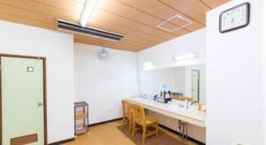 a room with a bathroom with a sink and a mirror at Tabist Marutora Bekkan Nishio Kira in Nishio