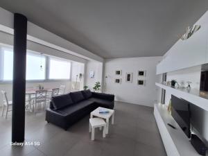 a living room with a black couch and a table at Perla delle Egadi in Marsala