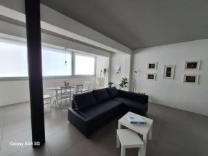 a living room with a black couch and a table at Perla delle Egadi in Marsala