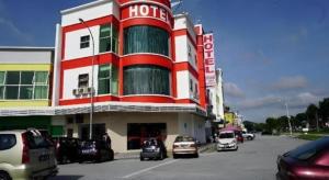 a hotel with cars parked in front of a parking lot at Hotel Kristal in Seri Iskandar