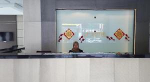 a woman is standing in front of a mirror at LF Hotel Tapah in Kampar