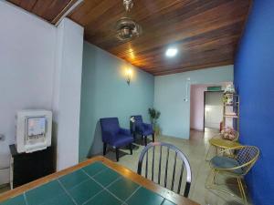 a living room with a table and chairs and a tv at Hotel Mansya in Kota Bharu
