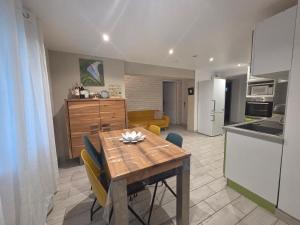 a kitchen and living room with a wooden table and chairs at Appartement Sophie à Vals les bains in Vals-les-Bains