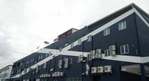 a large blue building with windows and a red at Kidurong Inn in Bintulu