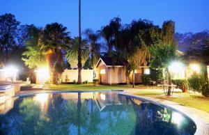 a swimming pool in front of a house at night at Kadoma Hotel & Conference Centre in Kadoma