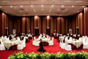 a banquet hall with white tables and white chairs at Hotel Scholar's Suites in Tanjung Malim +137 photos