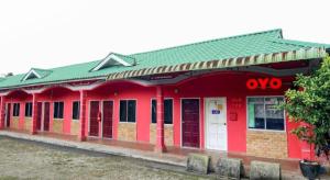 a red building with a green roof at OYO 89684 Mawaddah Inn Stay in Tangkak