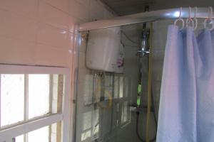 a shower in a bathroom with a window and a curtain at Nic's Inn in Freetown +24 photos