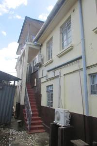 a white building with a door and a microwave at Nic's Inn in Freetown