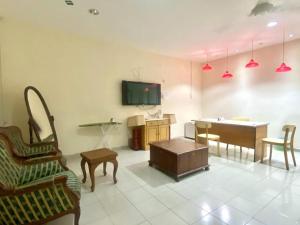 a living room with a tv and a table and chairs at OYO 90381 Chaah Homestay 3 in Segamat