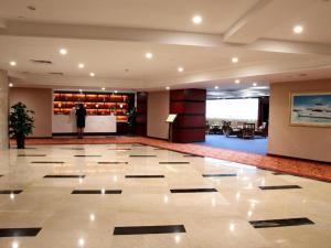 a lobby with a large marble floor with a person in the background at Shunde Emperor Hotel in Shunde