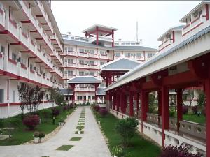 a large building with a pathway in front of it at Century Land Hotel Wuyishan in Wuyishan