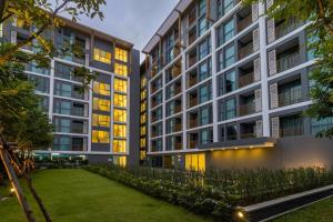 an apartment building with a lawn in front of it at C240 New Prime Location 1BR Condo Near Beach Club in Thalang