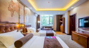 una camera d'albergo con due letti e una TV a schermo piatto di James Joyce Coffetel·Lijiang Old Town Centeral a Lijiang