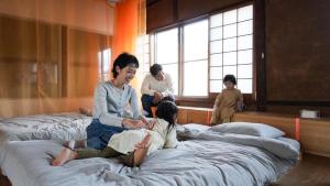 a group of people sitting on beds in a room at SEW STAY Soft Seam KYOTO MAIZURU in Maizuru +28 photos