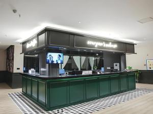 a store counter with a television in a building at City Comfort Premier Hotel Xiaogan Anlu Railway Station Dongda Times Square in Xiaogan