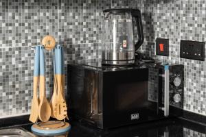 a kitchen counter with a blender on top of a microwave at Artful Gate Loft near Airport - Masdar City in Abu Dhabi