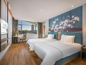 una camera d'albergo con due letti e un dipinto sul muro di Magnotel Hotel Dongxing Guomen Port a Fangcheng Altre 209 foto