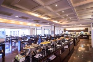 a dining room with tables and chairs with food at Twinstar Hotel in Taichung