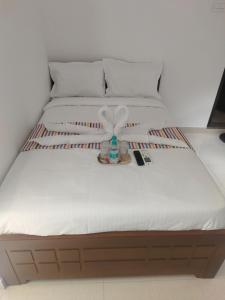 a bed with a white mattress with a bottle on it at Goldwins Grand A comfort stay in Coimbatore