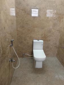 a bathroom with a toilet and a shower at Goldwins Grand A comfort stay in Coimbatore +4 photos