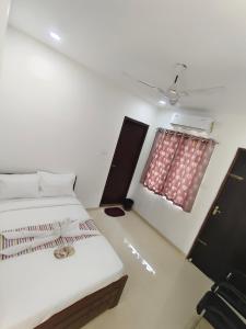a small room with a bed and a window at Goldwins Grand A comfort stay in Coimbatore