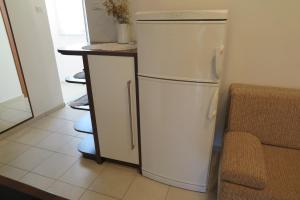a white refrigerator in a kitchen next to a counter at Apartment Omerovic in Novalja