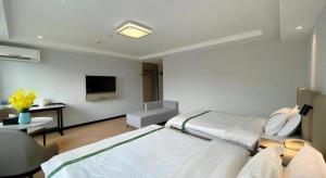 una stanza d'ospedale con un letto e una tv di GreenTree Inn Hefei East Wangjiang Road CTCE Express Hotel a Hefei