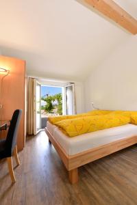 een slaapkamer met een bed, een bureau en een raam bij Hotel de la Gare in Sugiez