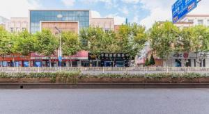a street in a city with buildings and trees at GreenTree Inn Yancheng Dongtai West Wanghai Road Shell Hotel in Dongtai