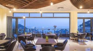 a restaurant with tables and chairs and a large window at Thang Loi Tam Dao Hotel in Tam Ðảo