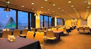 青森市にあるSunroute Aomori Hotelのテーブルと椅子と窓のある会議室