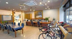青森市にあるSunroute Aomori Hotelのテーブルと椅子と自転車のあるレストラン