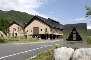 a building with a sign in front of a road at TOYOTA Shirakawa-Go Eco-Institute in Shirakawa