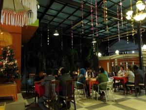 a group of people sitting at tables in a restaurant at Havilla Maranatha in Padang