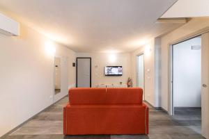 an orange couch in the middle of a room at Residenza Cavour - Appartamento D in Tirano +16 photos