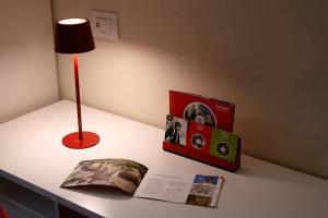 a table with a lamp and a book and a lamp at Residenza Cavour - Appartamento D in Tirano