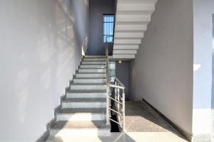 a staircase in a building with a metal railing at Hotel O Neatflix &Chill in Khandagiri +49 photos