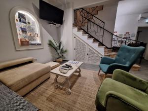 a living room with a couch and chairs and a staircase at Raiz Alentejana in Reguengos de Monsaraz