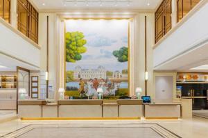 a large painting on the wall in a lobby at Vienna Hotel 5.0 Qingyuan City Plaza Lianjiang Road in Qingyuan