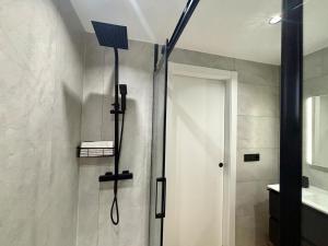a shower in a bathroom with a shower head at Holibai, Meiga Do Mar, Apto moderno, vistas al mar y playa cerca, Baiona in Baiona +17 photos