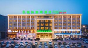 a large building with cars parked in a parking lot at GreenTree Inn Chifeng Ningcheng County Bus Station Branch in Xihusutai