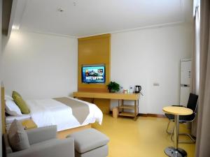 a bedroom with a bed and a desk with a tv at GreenTree Inn Xianning Tongshan Yangdu Avenue in Xianning